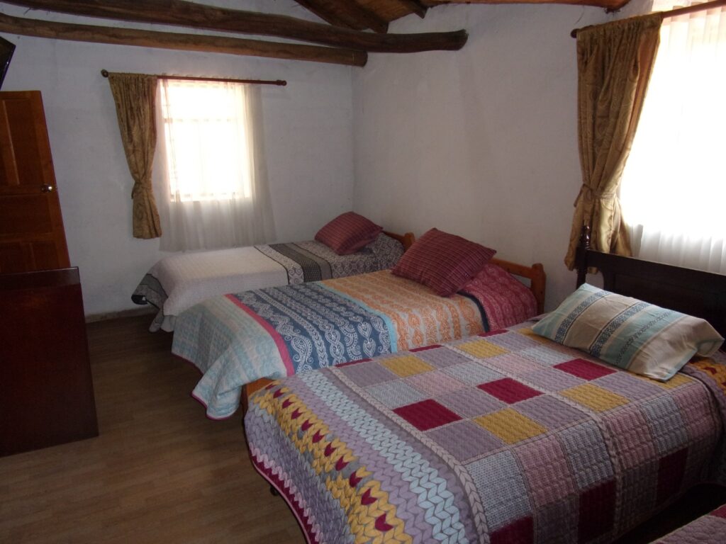 Muestra habitación con 4 camas sencillas.