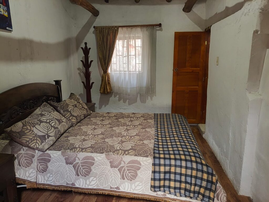 Imagen muestra la habitación Tópaga, en el Hostal Villa San Juan. Habitación doble estándar, con baño privado y vista a la montaña