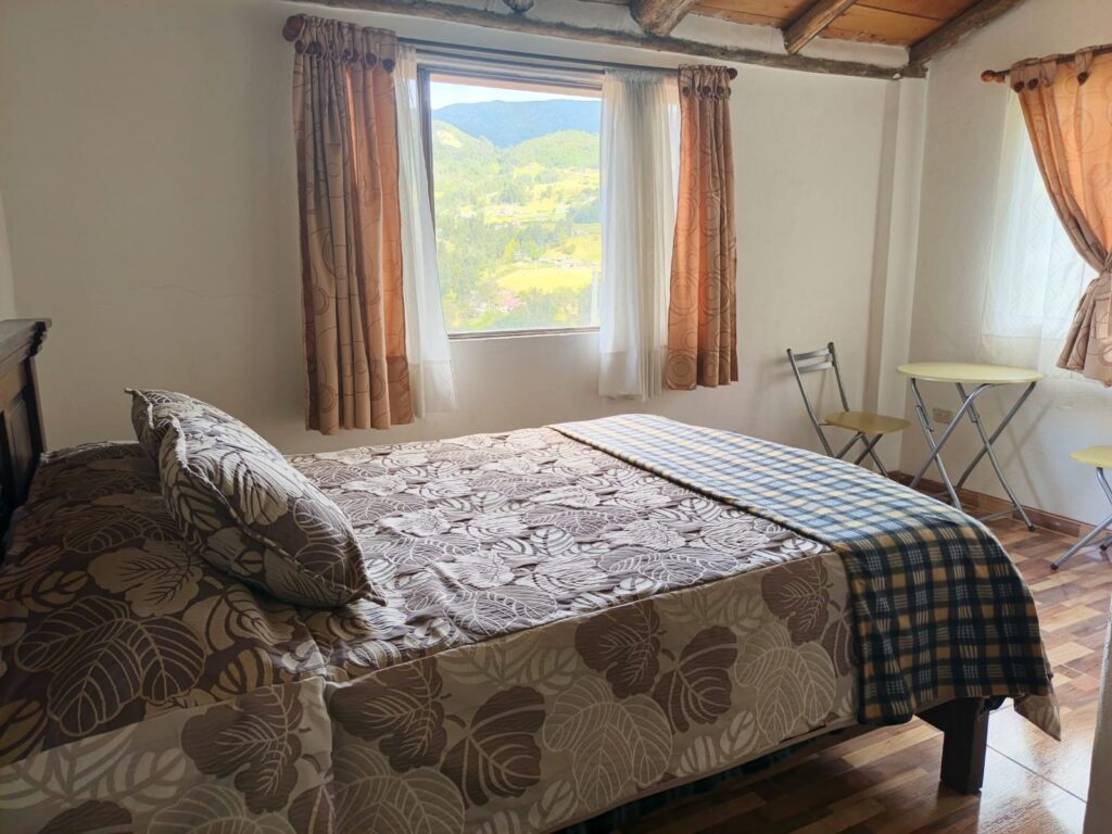 Imagen muestra la habitación doble de lujo Siscunsí. Con increíble vista a la montaña, mesa auxiliar, baño privado y total comodidad